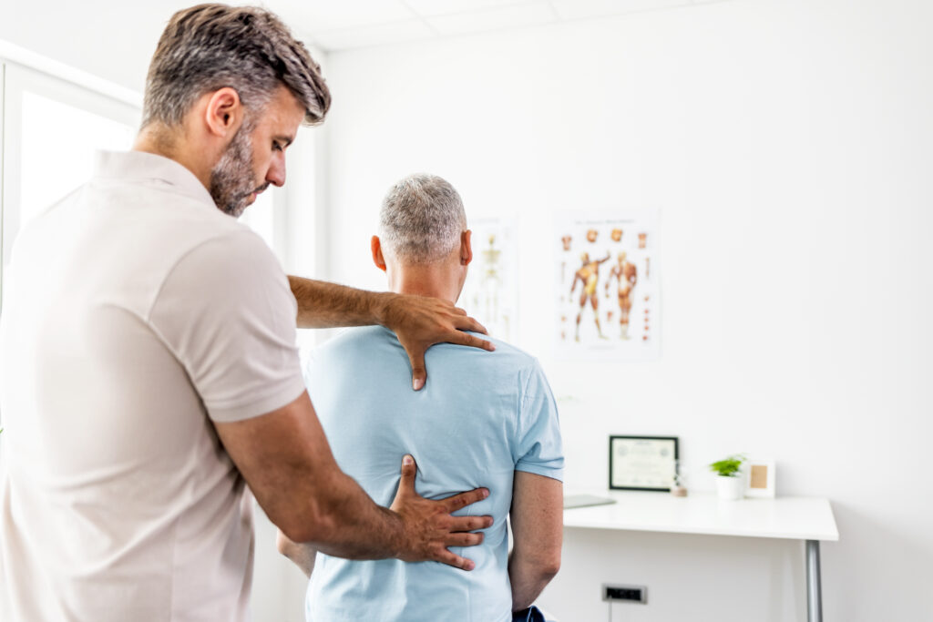 Mature man having chiropractic back adjustment.